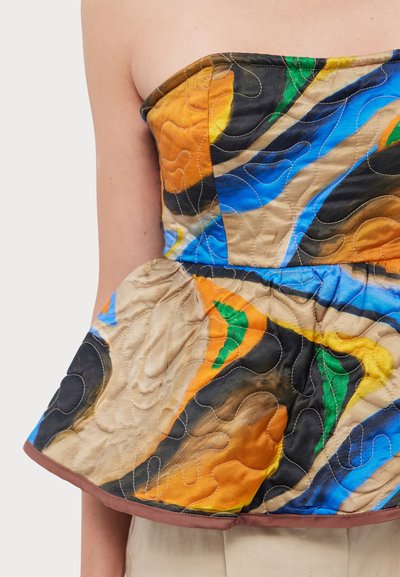 Top bez ramínek s peplum střihem a prošívanou texturou, s živými abstraktními vzory v oranžové, modré, zelené a hnědé barvě, orámované hnědým lemováním.