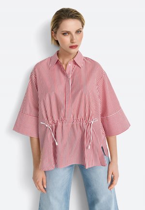 Maglietta a righe rosse e bianche con colletto, maniche corte e vita regolabile con cordoncino. Tessuto morbido, vestibilità comoda e spacchi laterali.