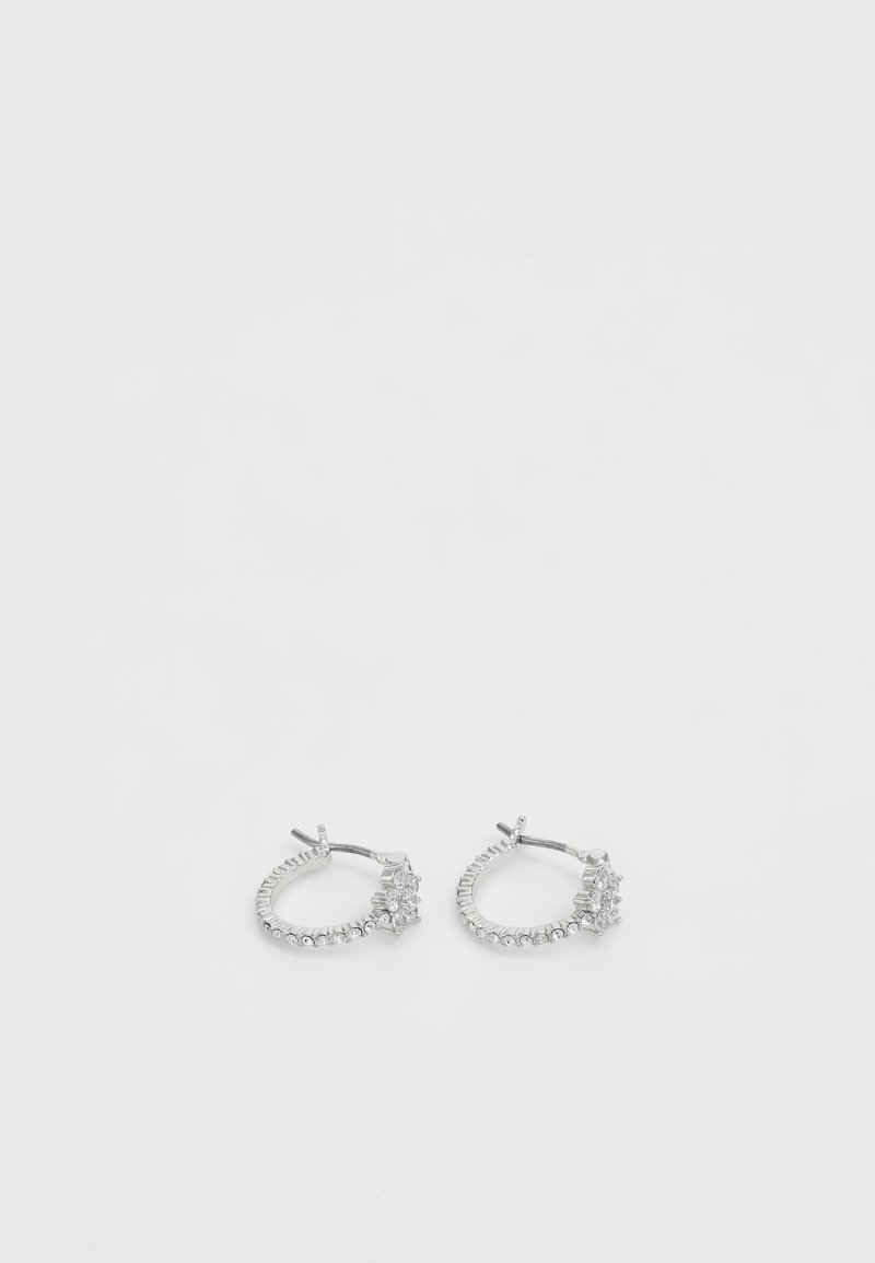 Silver hoop earrings featuring a row of small clear gemstones, with larger gems arranged asymmetrically on one side.