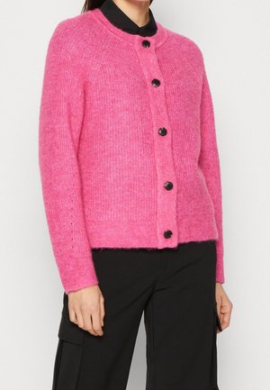 Cardigan rosa fuzzy con maniche lunghe, colletto tondo e cinque bottoni neri sul davanti. Texture morbida e vestibilità leggermente oversize.