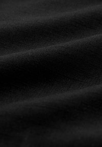 Textilstoff in mattschwarz mit glatter Textur, dezentem Glanz und leichten Falten, die seine leichte und flexible Beschaffenheit betonen.