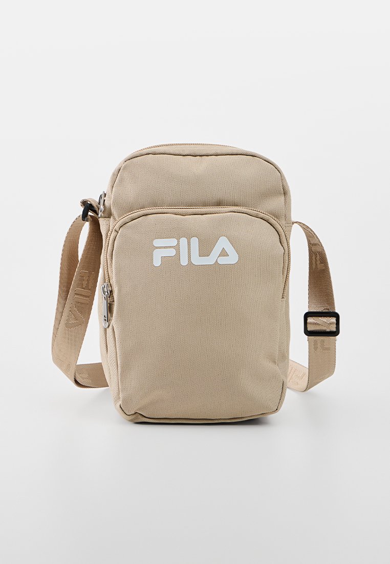 Beige canvas axelväska med justerbar rem, framficka med dragkedja och vitt logotyp. Rektangulär form med slät textur och hållbar design.