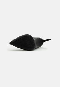 Escarpin noir à talon aiguille avec une semelle en caoutchouc texturé. Dessus lisse au design minimaliste, présentant un talon élancé et une silhouette étroite.