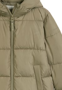 Puffer jacket in olive green, featuring a zip front, hood, and quilted texture. Notable brand logo on the sleeve. Soft fabric finish.