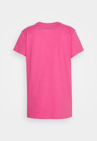 Camiseta de manga corta en algodón rosa brillante, con cuello redondo y un diseño liso en la parte posterior. Textura suave sin patrones ni acentos.