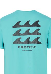 Turquoise t-shirt met een zwart golvenpatroon op de achterkant, met het woord "PROTEST" en "SINCE 1993" eronder.