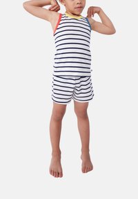 Set di top a maniche corte e pantaloni corti a strisce bianche con strisce navy. Presenta una bordatura colorata sulle spalle in rosso, giallo e blu. Tessuto morbido.