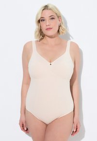 Beige badpak met brede bandjes, gevormde cups en een klein decoratief strikje in het midden. Glad materiaal met een naadloos ontwerp.