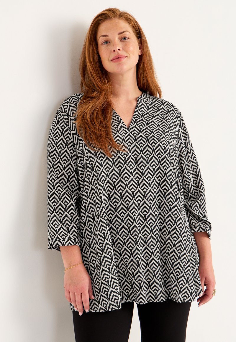 Black and white patterned blouse with a V-neck and three-quarter sleeves, featuring a geometric design on lightweight fabric.