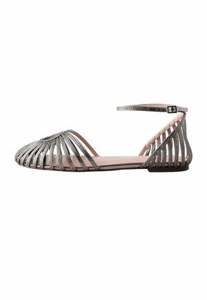 Silver flat sandal with strappy jeweled design, ankle strap, and closed pointed toe, shown in side profile on a white background.