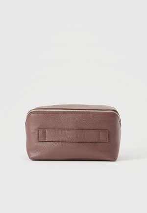 Trousse de toilette rectangulaire en cuir marron avec fermeture éclair argentée et poignée cousue à l’avant, présentée sur un fond clair uni.