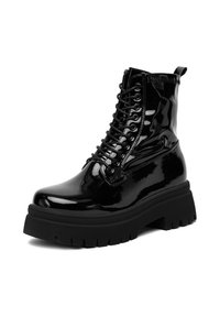 Czarne lakierowane buty wojskowe z grubą podeszwą, sznurowane z przodu, z pętelką na tylnej części cholewki.