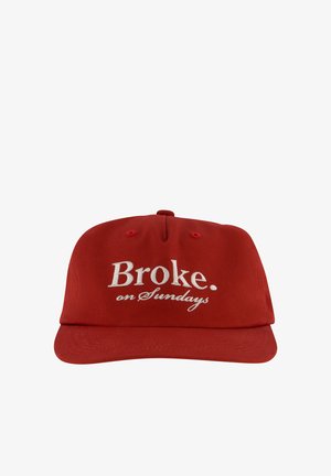 Gorra de béisbol roja con texto bordado en blanco que dice "Broke. on Sundays" en el panel frontal.