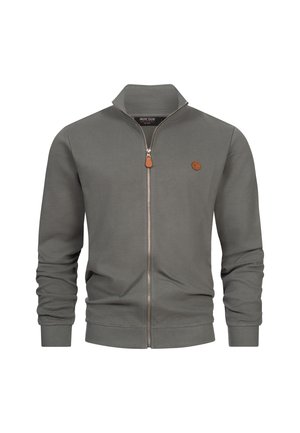 Graue Zip-Jacke aus geripptem Stoff, mit Stehkragen, langen Ärmeln, einem braunen Leder-Logo-Patch und einem silbernen Reißverschluss.