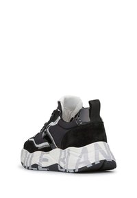 Sort og hvid sneaker med tyk sål, der har abstrakte grå mønstre, overdel i ruskind og mesh samt en pull-tab bagpå.