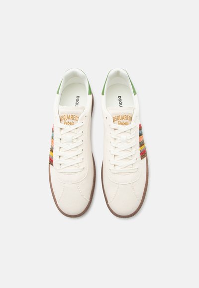 Ζευγάρι λευκά πάνινα αθλητικά παπούτσια με πράσινες ταμπέλες στη φτέρνα, πολύχρωμες ρίγες στο πλάι, καφέ σόλες και το σήμα "Dsquared2 Rebels" στη γλώσσα.