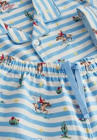 Blauw pyjamastel met witte strepen, met patronen van cowboys en cactussen. Zachte stof met een knopenoverhemd en een verstelbare tailleband.