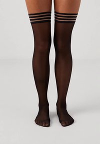 Mustad reied üle põlve sukad, millel on elastsed ribad, millel on ülaosas kolm horisontaalset triipu. Sile ja läbipaistev tekstuur, avatud varbaga disain.