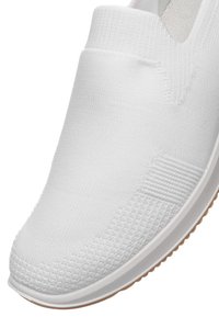 White knitted slip-on sneaker with textured patterns on the upper and a white sole featuring a tan rubber outsole edge.