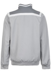 Chaqueta ligera gris con cuello alzado, rayas blancas en los hombros y puños y dobladillo elásticos. Acabado de tela texturizada.