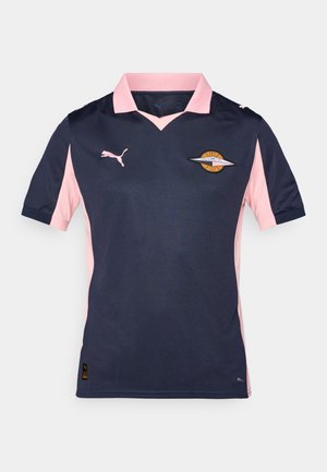 Un jersey à manches courtes de couleur bleu marine et rose avec un col en V, arborant un logo sur la poitrine. Fabriqué en matériau respirant. Marque Puma sur les manches.