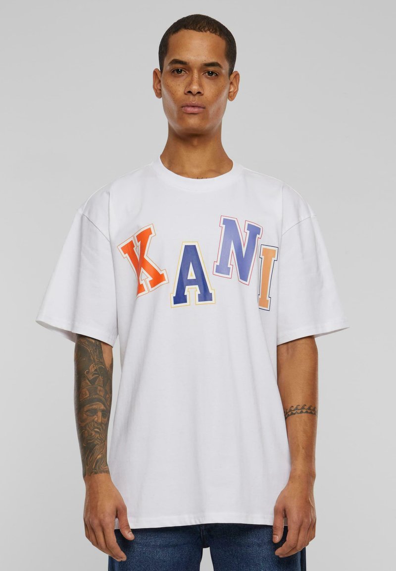 White cotton t-shirt featuring bold multicolored letters "KANI" in orange, yellow, blue, and purple. Relaxed fit with short sleeves.