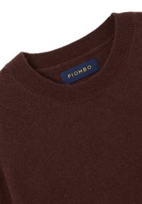Maglione lavorato a maglia marrone con collo rotondo a coste. L'etichetta riporta "PIOMBO" in giallo su uno sfondo blu navy. Texture morbida con cuciture uniformi.