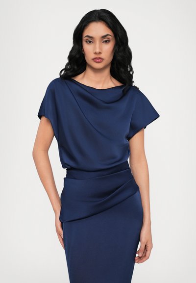Navy blue dress with a draped neckline and short sleeves. Smooth satin texture, featuring a fitted waist and a gathered accent at the hip.