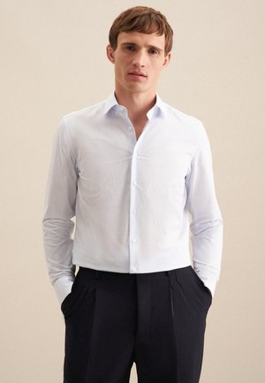 Wit en lichtblauwe gestreepte blouse met lange mouwen, een puntkraag en knoopsluiting, gecombineerd met donkere dress pants. Zachte textuur.