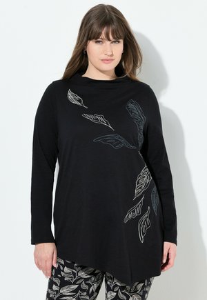 Zwarte top met lange mouwen en een asymmetrische zoom, versierd met bladvormen in wit en grijs, gemaakt van zachte, lichte materialen.
