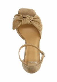 Naakt suède sandaal met een geknoopte strikdetail bij de teen, een iets gevoerd voetbed en een verstelbaar enkelbandje met een gespsluiting.