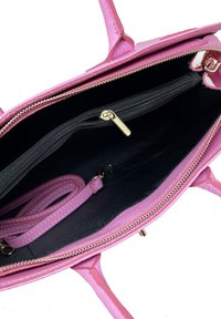 Růžová kožená kabelka s texturovaným povrchem, zlatým zipem a černým podšívkou. Uvnitř se nachází kapsa na zip a odnímatelný popruh.