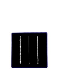 Drie zilveren kettingen tentoongesteld op een zwart fluwelen achtergrond in een blauwe doos. Eén ketting heeft schakels, een andere is glad en de derde is gedraaid.