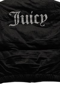 Giacca nera in velluto con superficie lucida, caratterizzata da un logo "Juicy" in strass scritto in corsivo sul petto. Orlo elastico nella parte inferiore.