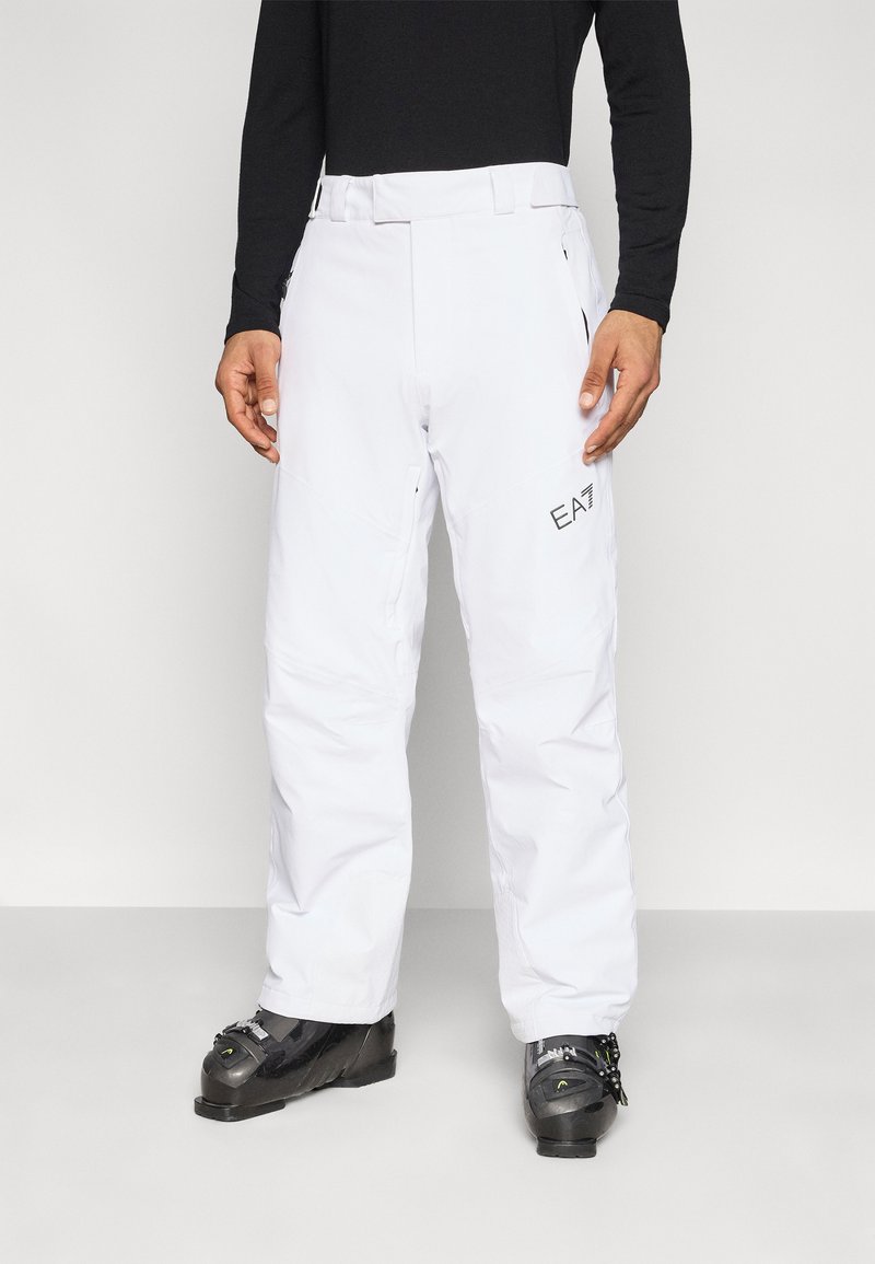 Άσπροι σκι παντελόνια από αδιάβροχο υλικό, με εμφανές λογότυπο, ευθεία γραμμή, έξι τσέπες και ενισχυμένες ραφές για ανθεκτικότητα.