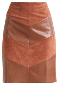 Jupe en patchwork de cuir et de daim marron avec un motif en chevron, taille haute et longueur au-dessus du genou.