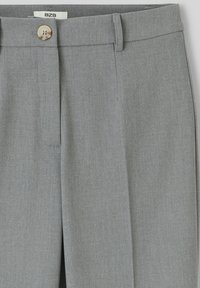 Pantalons gris ajustés en tissu texturé, dotés d'une fermeture à bouton, d'un devant plat et de plis marqués pour une allure structurée.