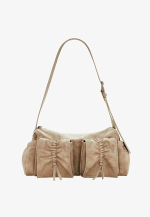 Beige nahkalaukku pyöreällä muotoilulla, jossa on kolme rypytettyä taskua edessä ja yksi säädettävä hihna.