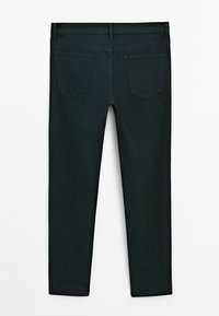 Jean en denim vert foncé avec une coupe près du corps, une conception à cinq poches et une finition mate et lisse. Les poches arrière sont inclinées.