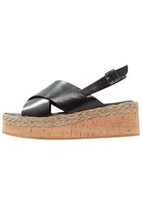 Černé kožené platformové sandály s tkaným jute mezipodešví, designem křížových pásků a nastavitelným páskem kolem kotníku. Plná strukturovaná podrážka.