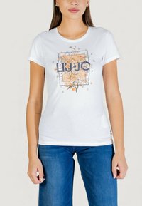 Camiseta blanca de algodón con un diseño floral y el nombre de la marca "LIU JO" en el centro, mangas cortas y un cuello redondo clásico.