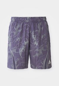 Violet urheilushortsit, joissa on abstrakteja hopeisia kuvioita, joustava vyötärönauha, sivuputket ja Adidas-logo oikeassa alalaidassa.