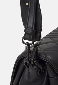 Borsa a tracolla nera in pelle trapuntata con design strutturato. Presenta dettagli in hardware dorato e doppi tiranti della zip con branding.