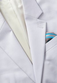 Light gray blazer with a smooth texture, featuring a white lining and a pocket square with blue and silver stripes.