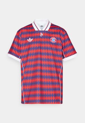 Fotbalový dres s šedobílým diamantovým vzorem v červené a modré barvě, s bílým límcem, s logem a brandingem na hrudi a rukávech.