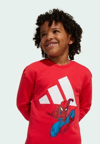 Red cotton sweatshirt featuring a large Spider-Man graphic and white logo on the front. Long sleeves and a round neck design.