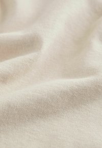 Light beige, soft fabric with a smooth, textured surface and fine weave pattern. No visible patterns or hardware details.