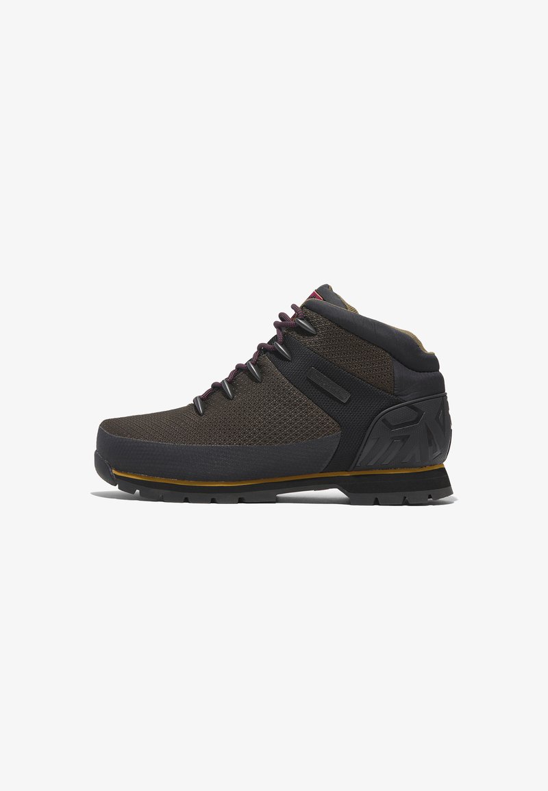 Chaussures montantes marron en matériaux en maille et synthétiques, avec semelle en caoutchouc et accents noirs contrastés. Elles sont dotées de lacets robustes et d'une surface texturée.