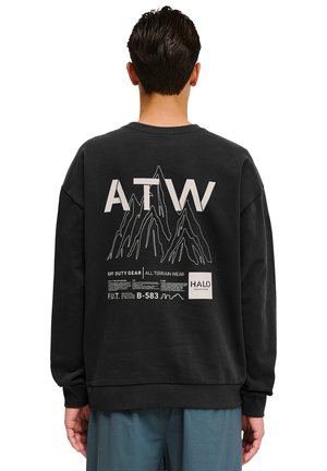Schwarzer Sweatshirt mit Rundhalsausschnitt, mit Grafiken eines Berges und Text auf dem Rücken. Weicher Stoff und entspannter Schnitt.