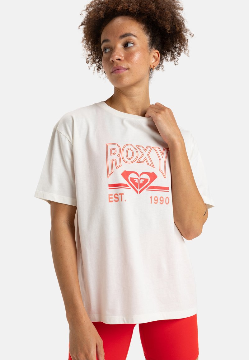 Weißes Baumwoll-T-Shirt mit kurzen Ärmeln, das ein auffälliges korallenfarbenes Grafikdesign mit dem Schriftzug "ROXY" und einem Herz-Logo zeigt, mit "EST. 1990" darunter.